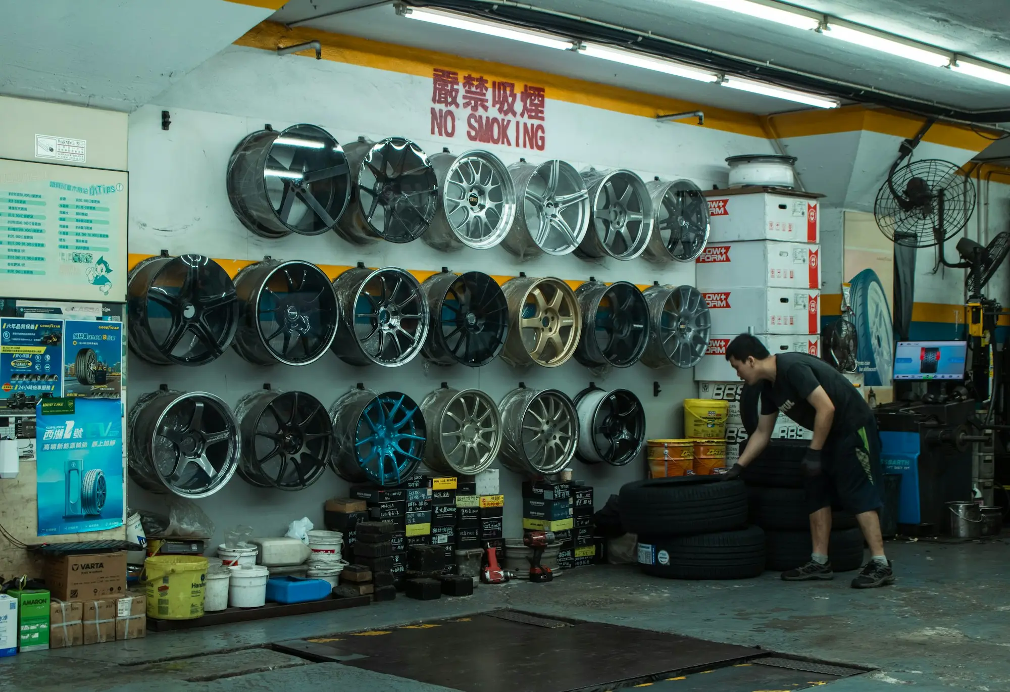 A worker stacking tyres in an auto shop, the stock a mid-sized business loan can fund