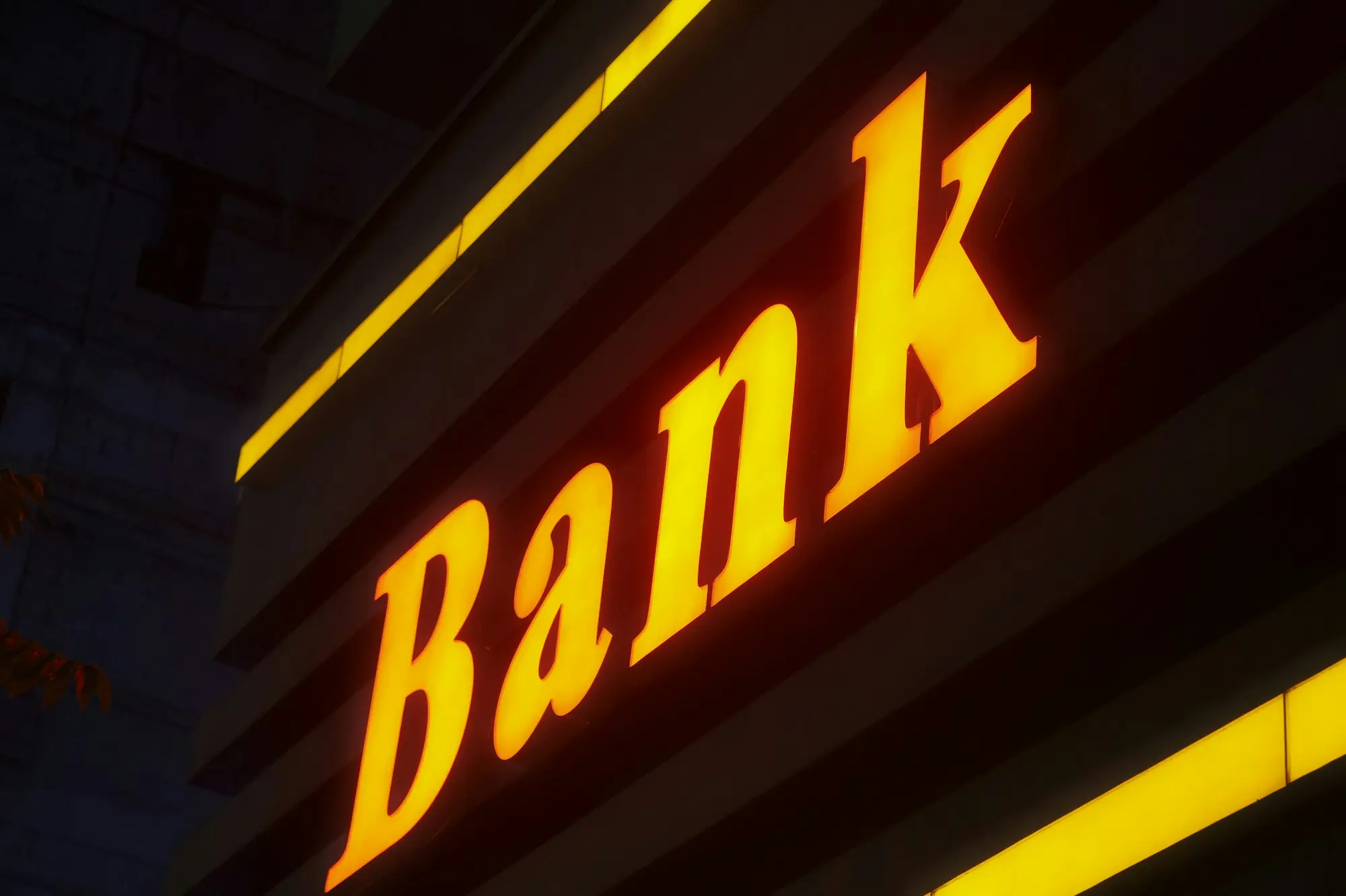 A lit bank sign at night, the refinance that becomes the exit from a short-term property loan