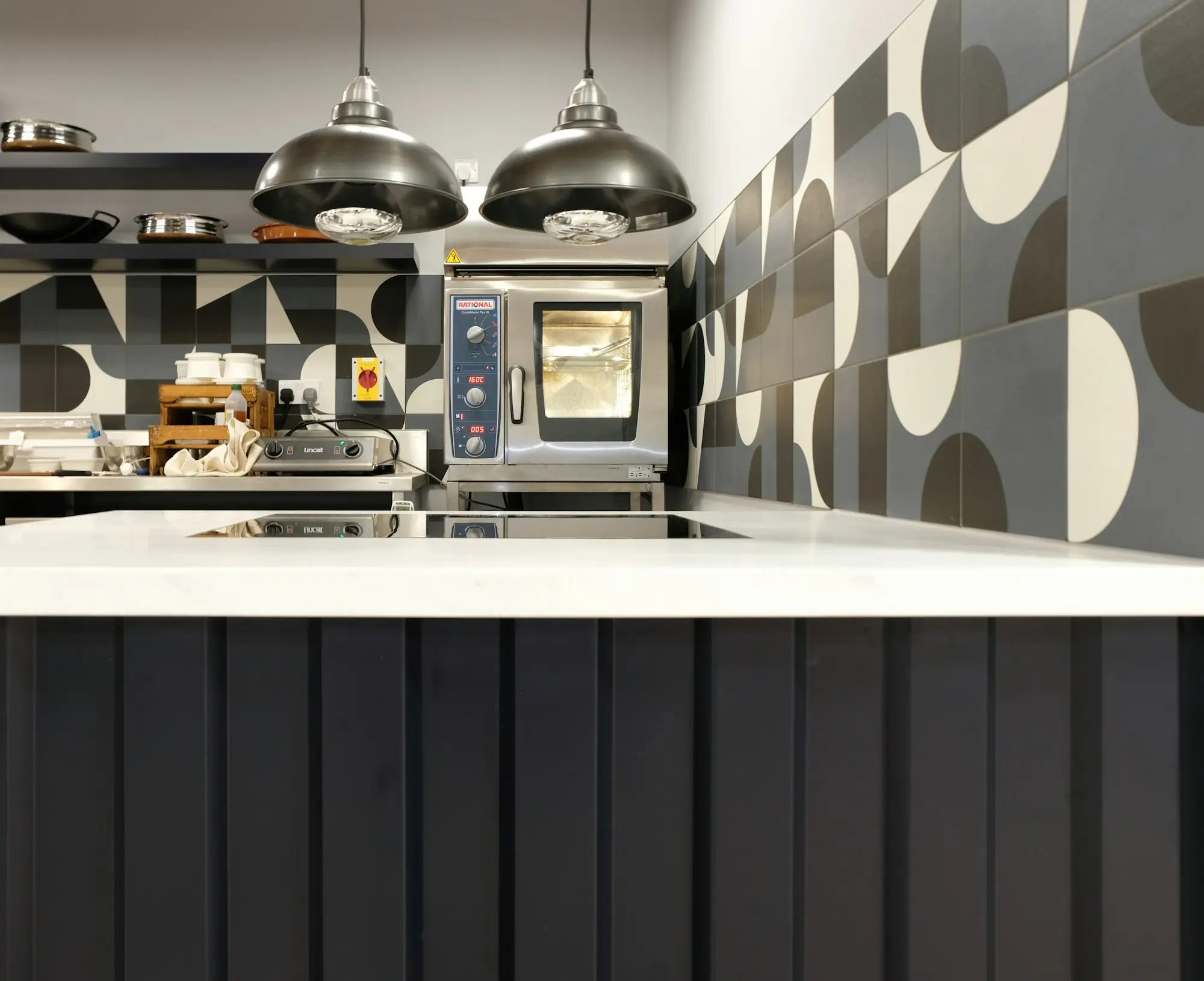 A cafe kitchen counter with patterned tiles and pendant lights, a business that draws on a line of credit