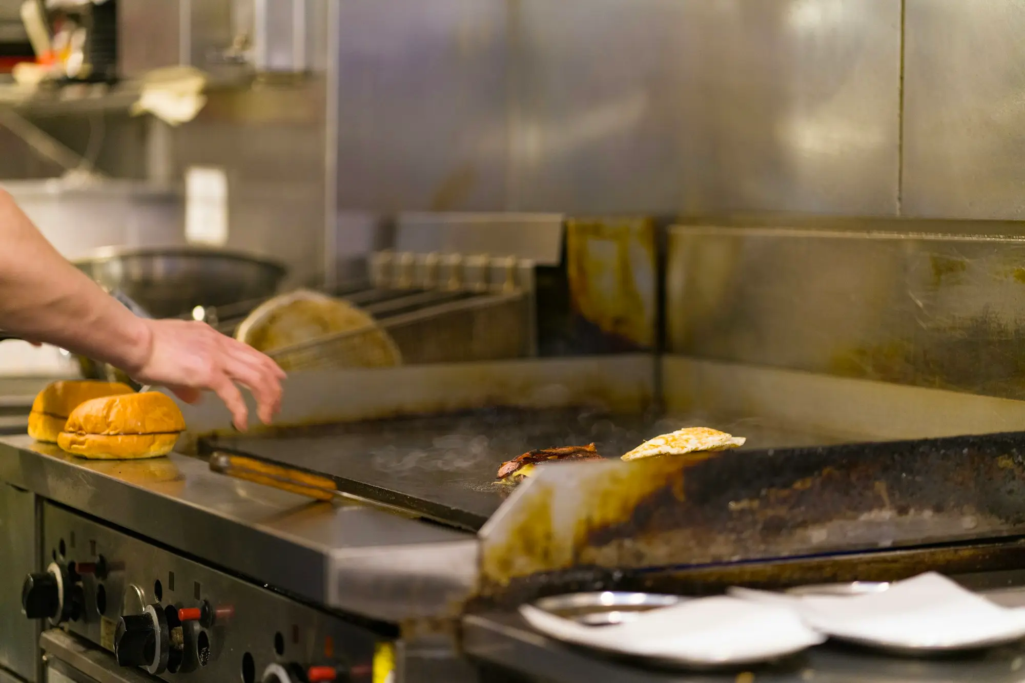 A chef cooking on a commercial grill in a restaurant kitchen funded for growth