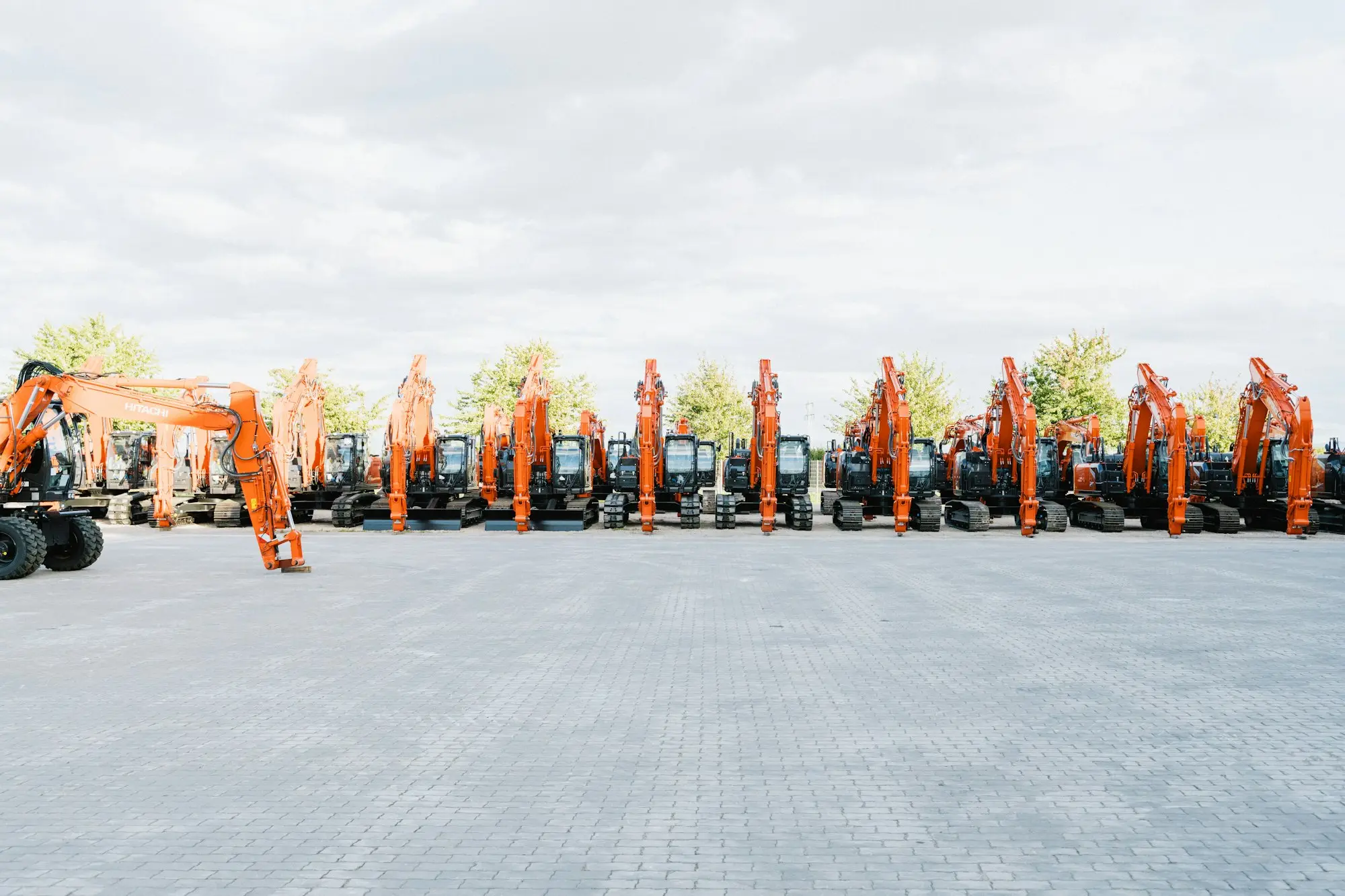 A row of new orange tractors in a dealer yard, equipment that can be funded fast